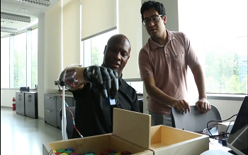 two people testing a prosthetic hand